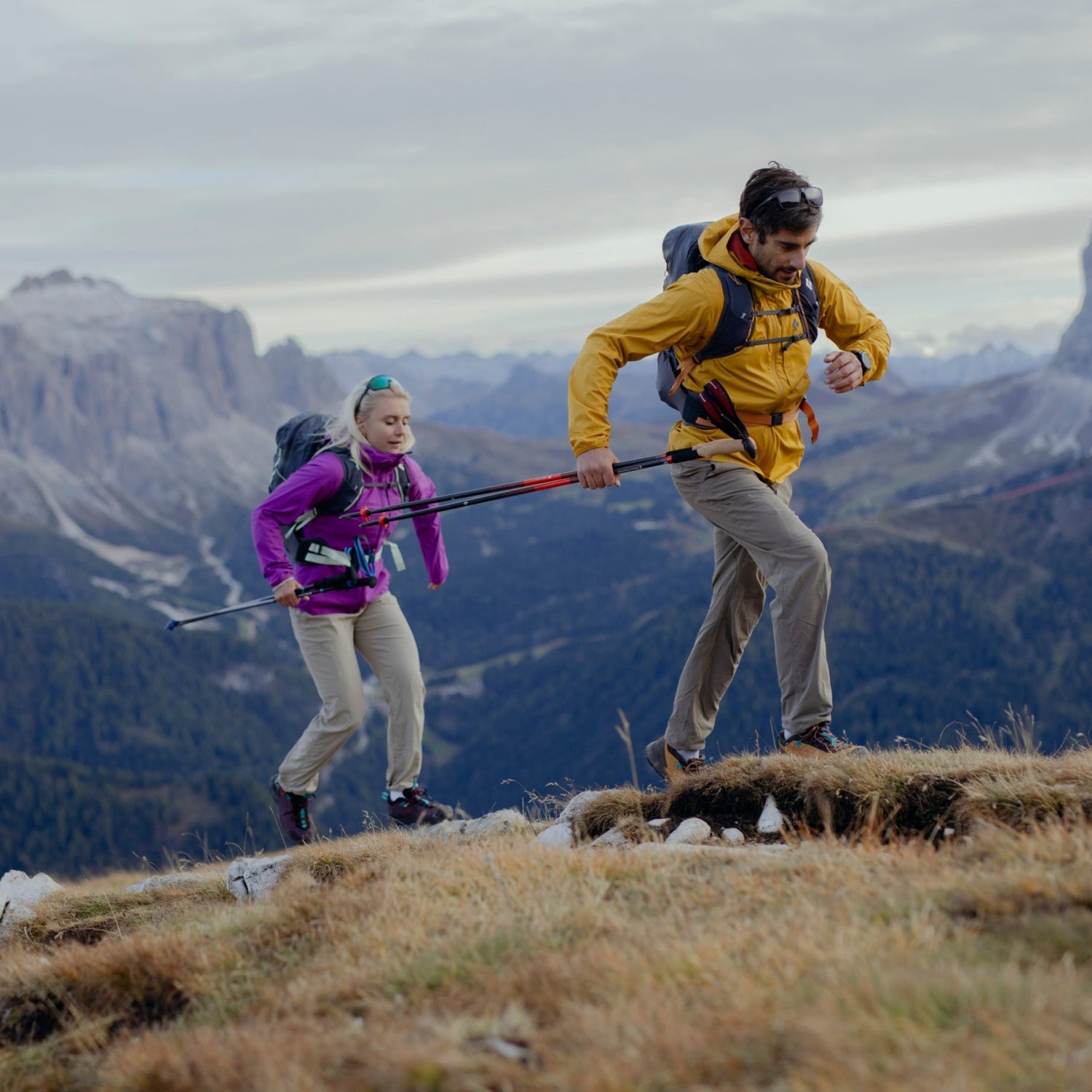 Two hikers in the BD Pursuit Collection jog up a hill.