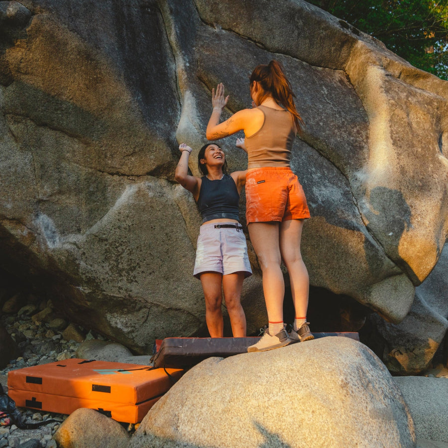 Two boulders high five after a climb.