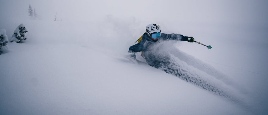 A skier charges through deep snow
