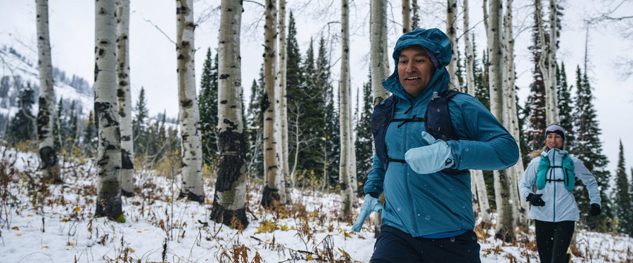 A runner runs through snowy aspens in Wyoming