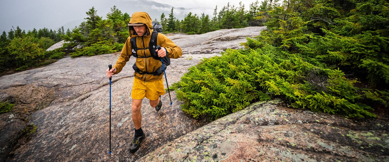 A hiker uses his Black Diamond trekking poles on slab rock