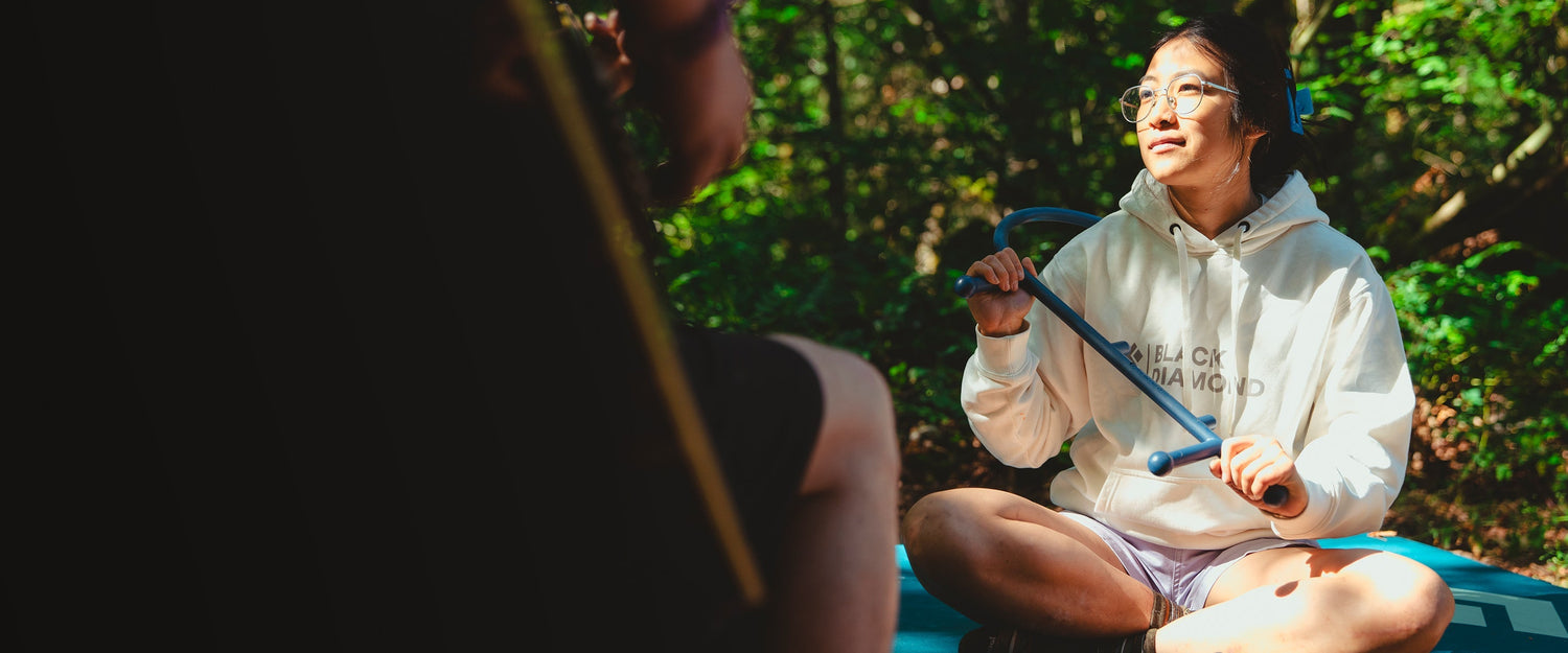 A climber massages their shoulder with a theracane