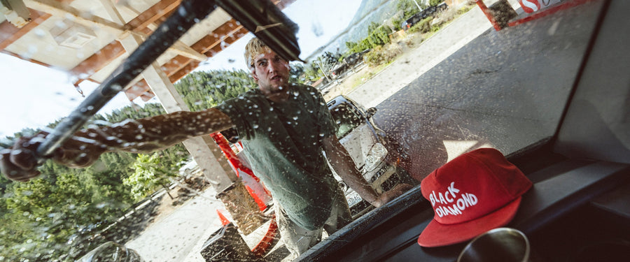 A climber washes a van windshield