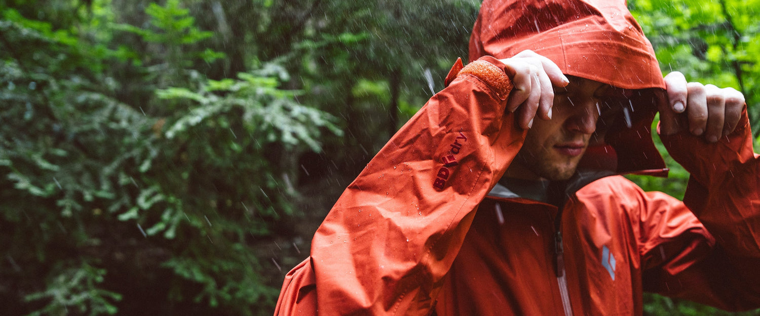 A man adjusts his hood in the rain
