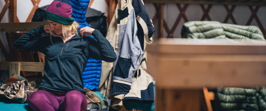 A woman sits on a bunk in a Yurt
