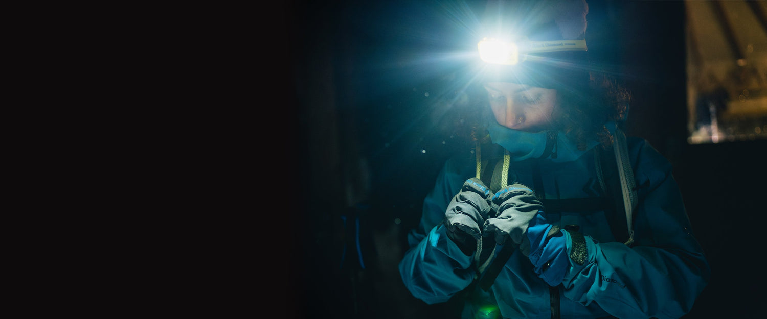 A skier adjusts a strap on her pack