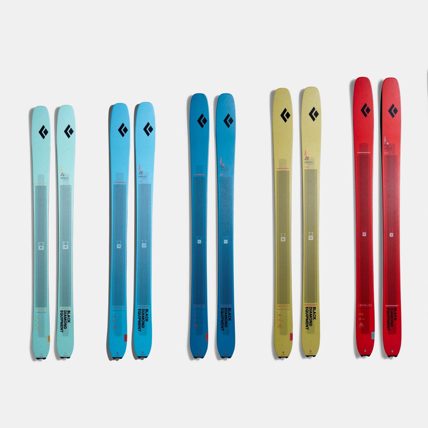 Set of skis in various colors on a white background