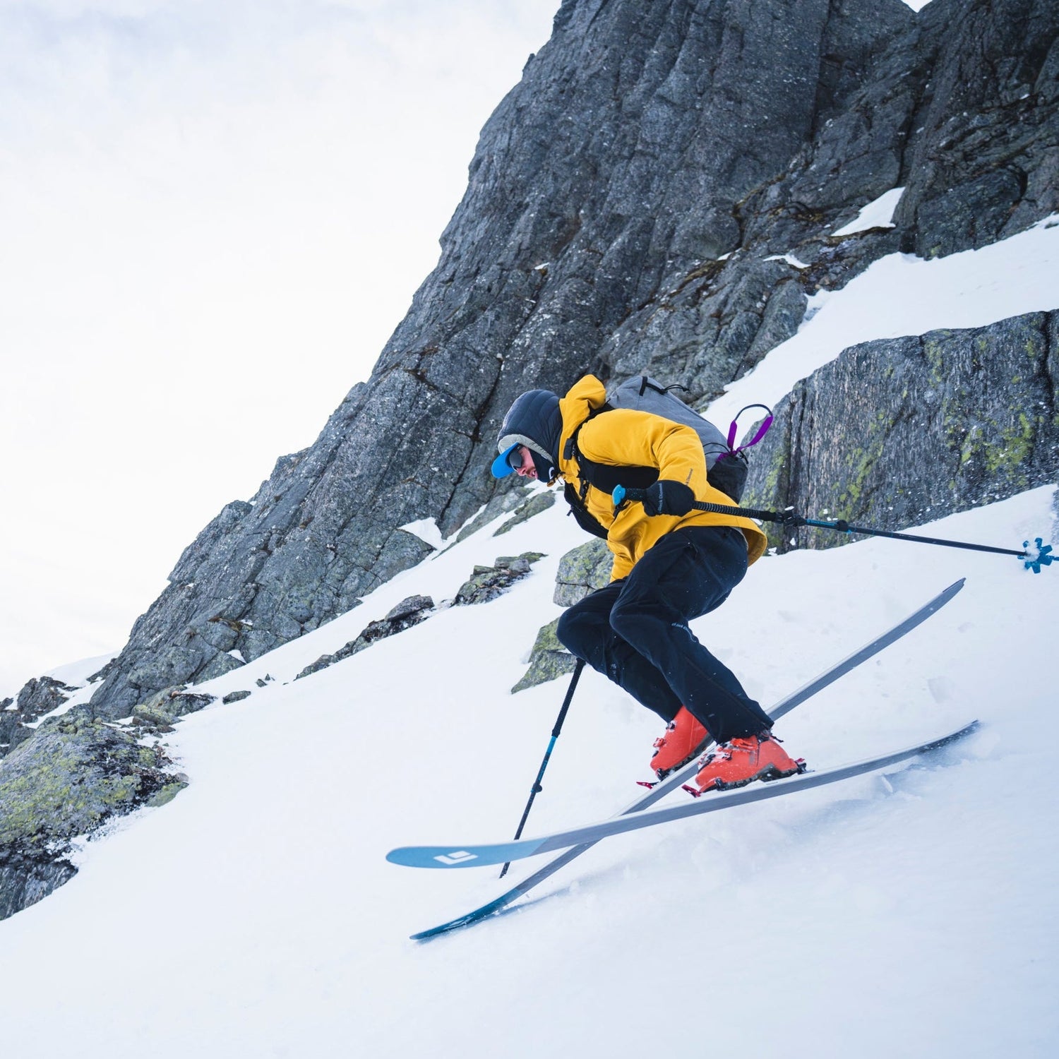 Skier in mid-air against a mountainous snowy landscape