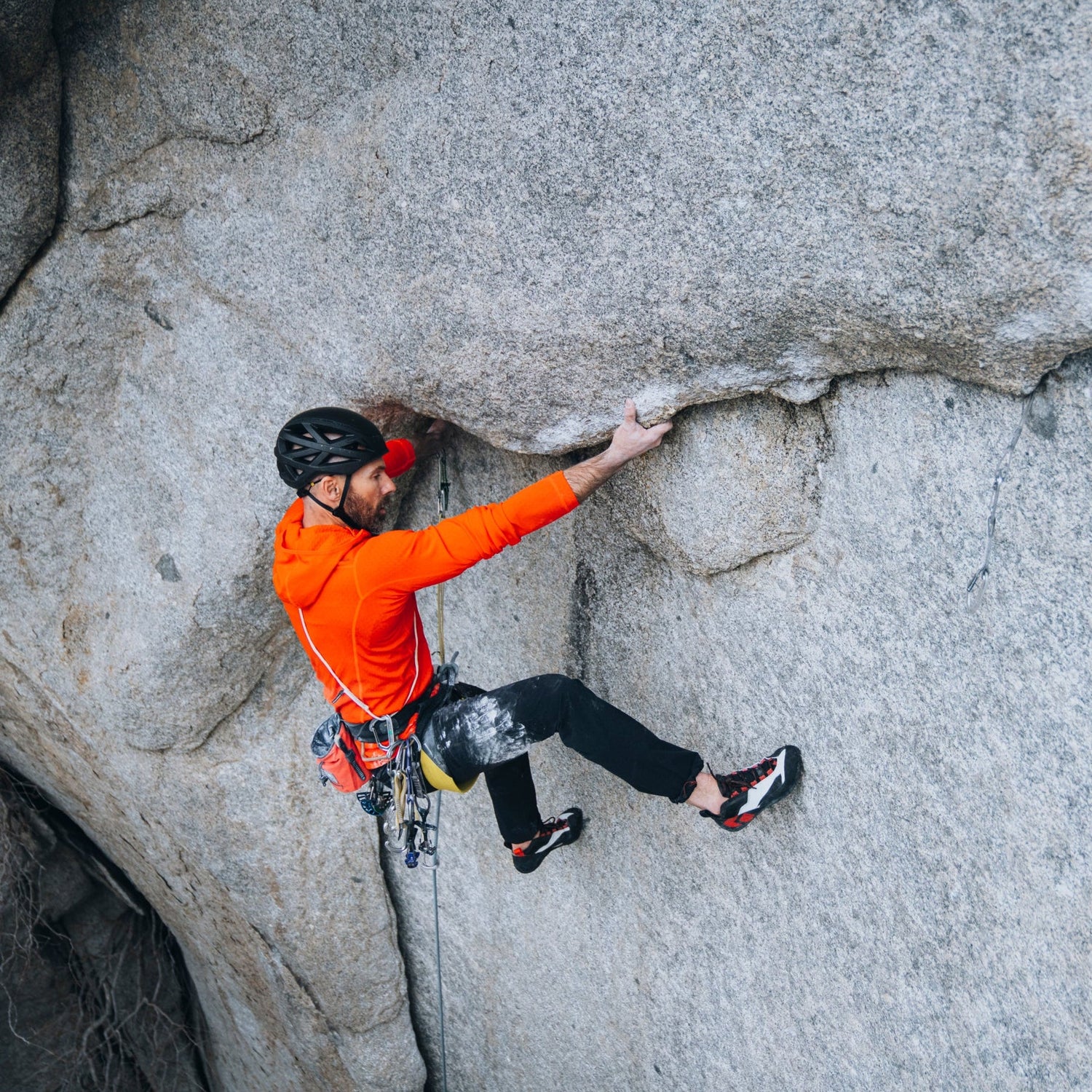 A climber wearing Aspect Pros on a granite climb.