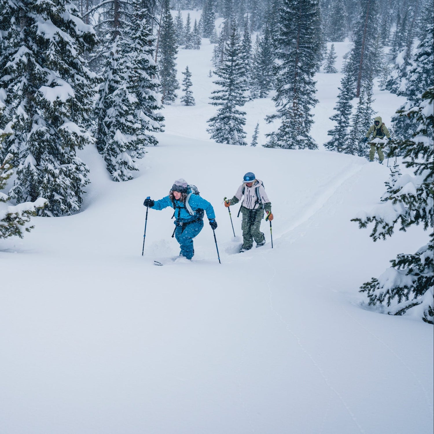 Two backcountry skiers breaking trail in deep powder.